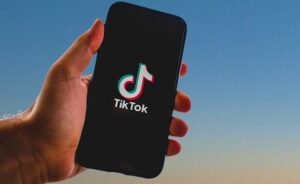 Joven con un celular en la mano con la aplicación de Tik Tok