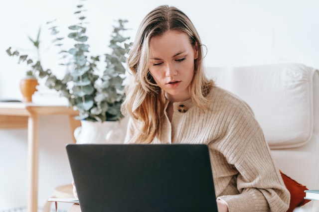 Mujer revisando su computador portatil, viendo sus cualidades.